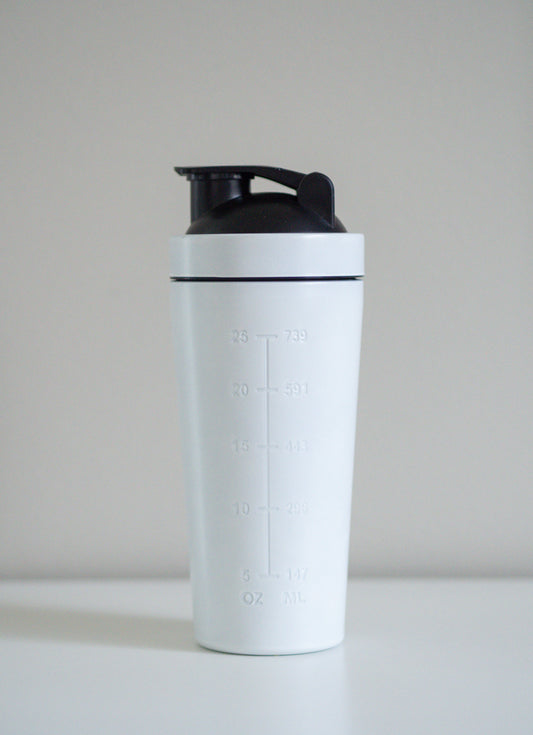 Minimalistinen ja moderni valkoinen terässheikkeri, joka erottuu edukseen perinteisistä muovimalleista – mukana metallikansi ja sekoituspallo.